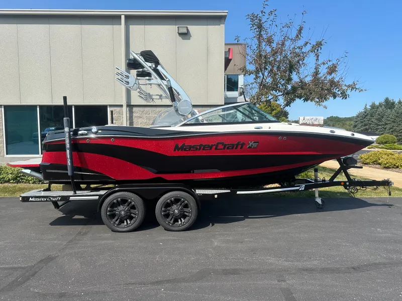 The Image of 2017 MasterCraft XT20 boat on trailer in front of building. - 1