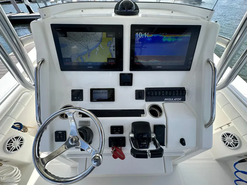 Slide: The Image of Control panel of a 2017 Regulator 31 boat with navigation screens and steering wheel. - 13