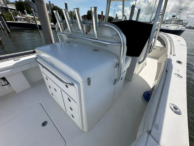 Slide: The Image of 2017 Regulator 31 boat interior with storage compartments and rod holders at a marina. - 18