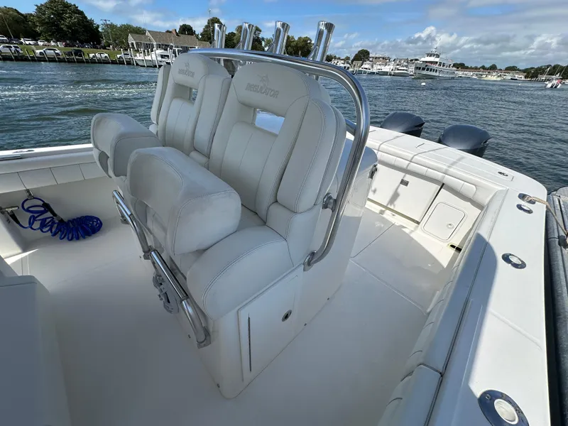 Slide: The Image of 2017 Regulator 31 boat interior with white seating and chrome details, docked by the water. - 19