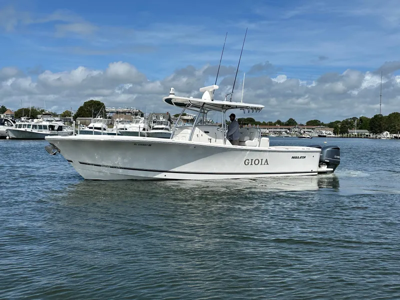 Slide: The Image of 2017 Regulator 31 boat named "Gioia" cruising on a calm waterway. - 2