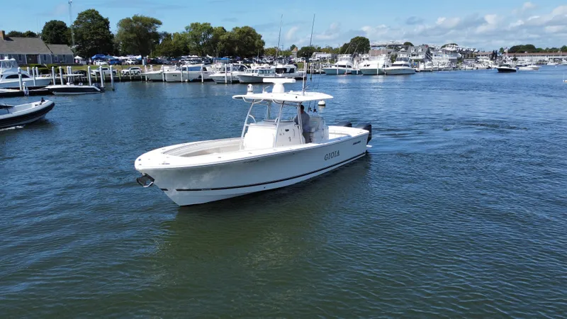 Slide: The Image of 2017 Regulator 31 boat cruising in a marina with other boats docked nearby. - 23