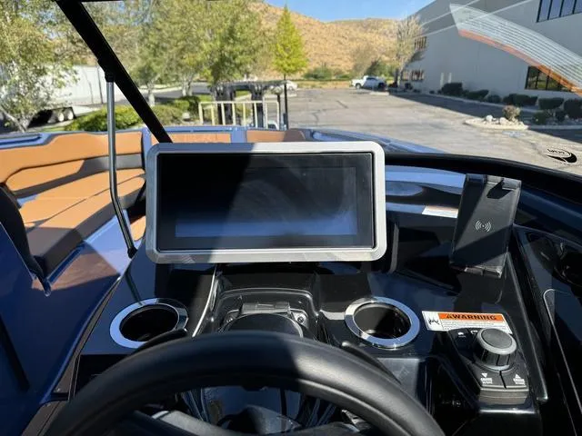 Slide: The Image of 2024 Yamaha Boats 255XD dashboard with touchscreen and controls in outdoor setting. - 10