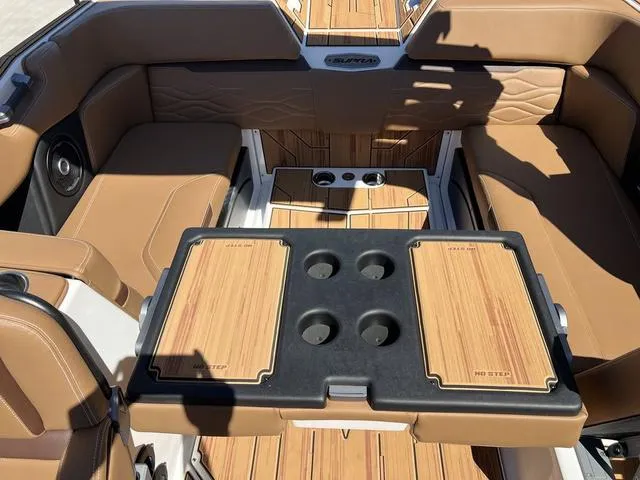 Slide: The Image of 2025 Supra SA 450 boat interior with tan seating and wooden table. - 14