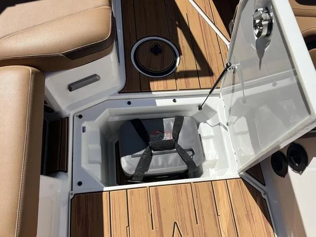 Slide: The Image of 2025 Supra SA 450 boat storage compartment with teak flooring and cushioned seating. - 15