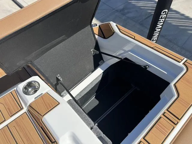Slide: The Image of Open storage compartment on 2025 Supra SA 450 boat with wood accents. - 18