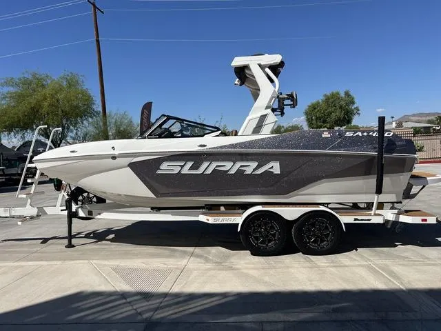 Slide: The Image of 2025 Supra SA 450 boat on trailer, parked outdoors under clear blue sky. - 5
