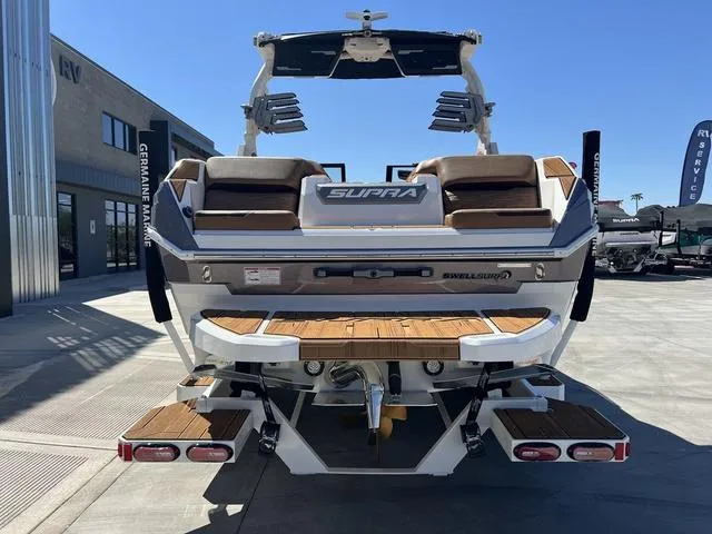 Slide: The Image of 2025 Supra SA 450 boat with teak deck, parked outdoors. - 7