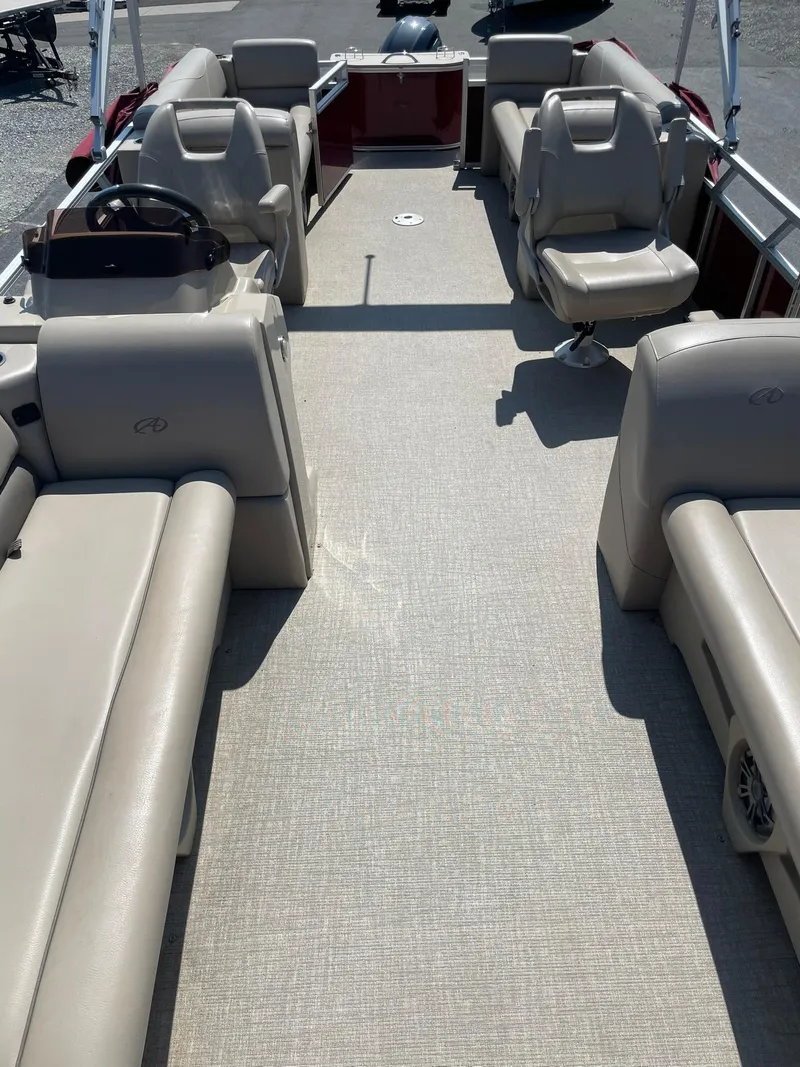 Slide: The Image of 2021 Avalon GS Cruise 23' pontoon boat interior with beige seating and steering console. - 11