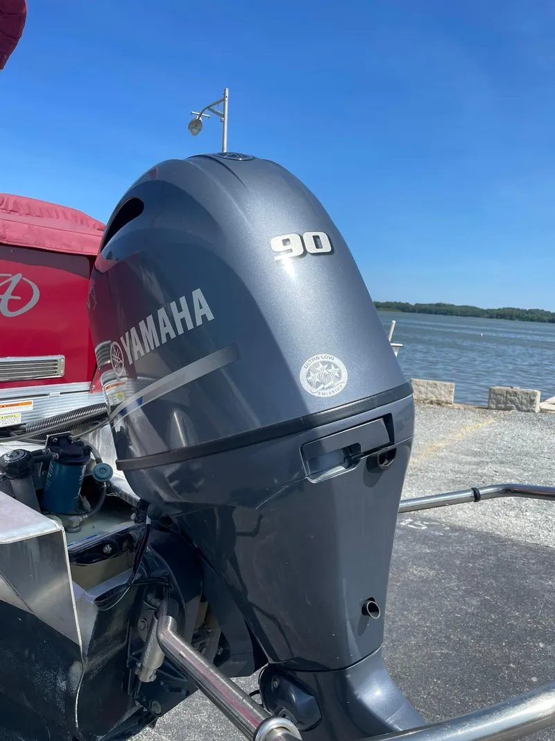 Slide: The Image of Yamaha 90 outboard motor on 2021 Avalon GS Cruise 23' boat by the water. - 5