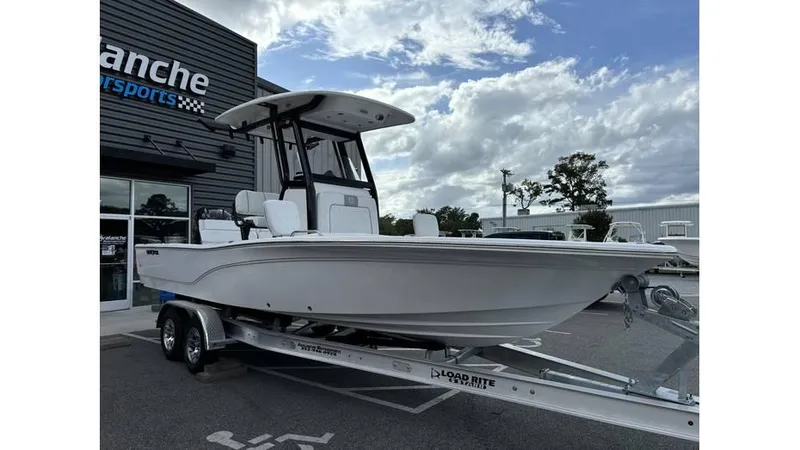 Slide: The Image of 2025 Sea Fox 251 Bay Fox boat on trailer at dealership, under cloudy sky. - 2