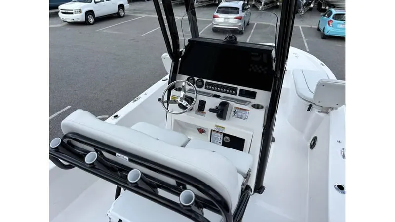 Slide: The Image of 2025 Sea Fox 251 Bay Fox boat interior with steering console and seating in a parking lot. - 4