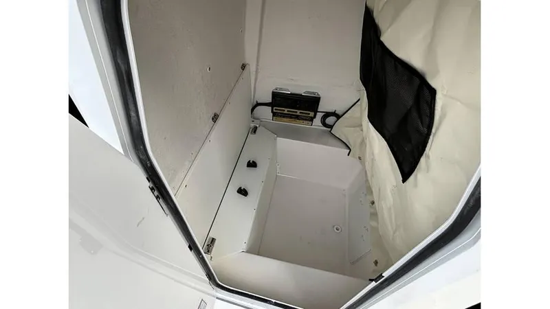 Slide: The Image of 2025 Sea Fox 251 Bay Fox storage compartment with white interior and black netting. - 8