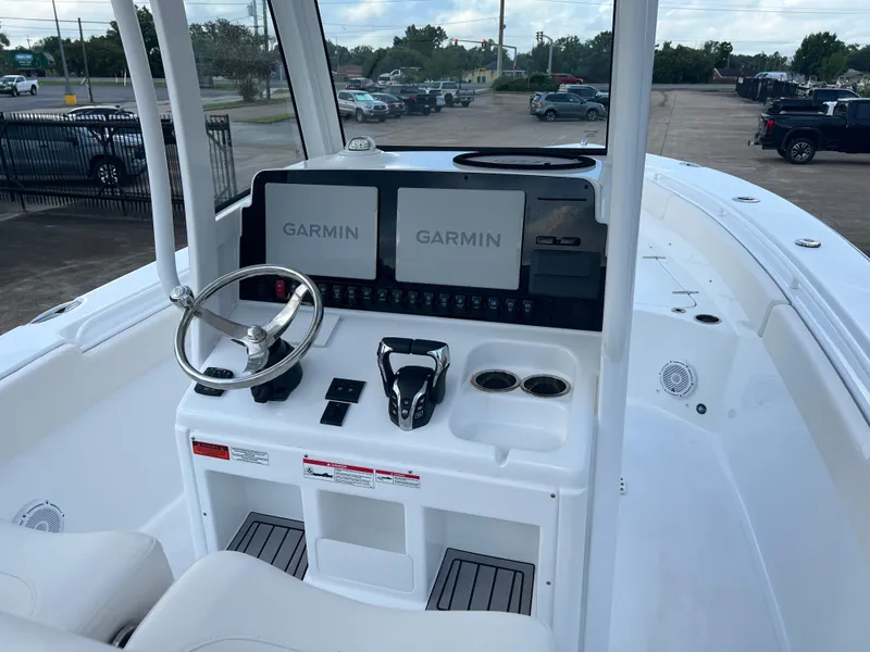 Slide: The Image of 2024 Sea Hunt Gamefish 27 FS boat dashboard with Garmin displays and steering wheel. - 10