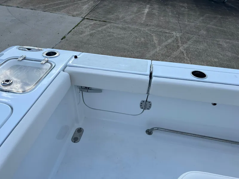 Slide: The Image of 2024 Sea Hunt Gamefish 27 FS boat interior, featuring storage and rod holders. - 11