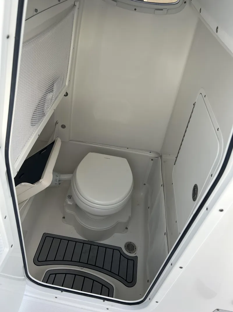 Slide: The Image of 2024 Sea Hunt Gamefish 27 FS boat interior bathroom with toilet and storage. - 15