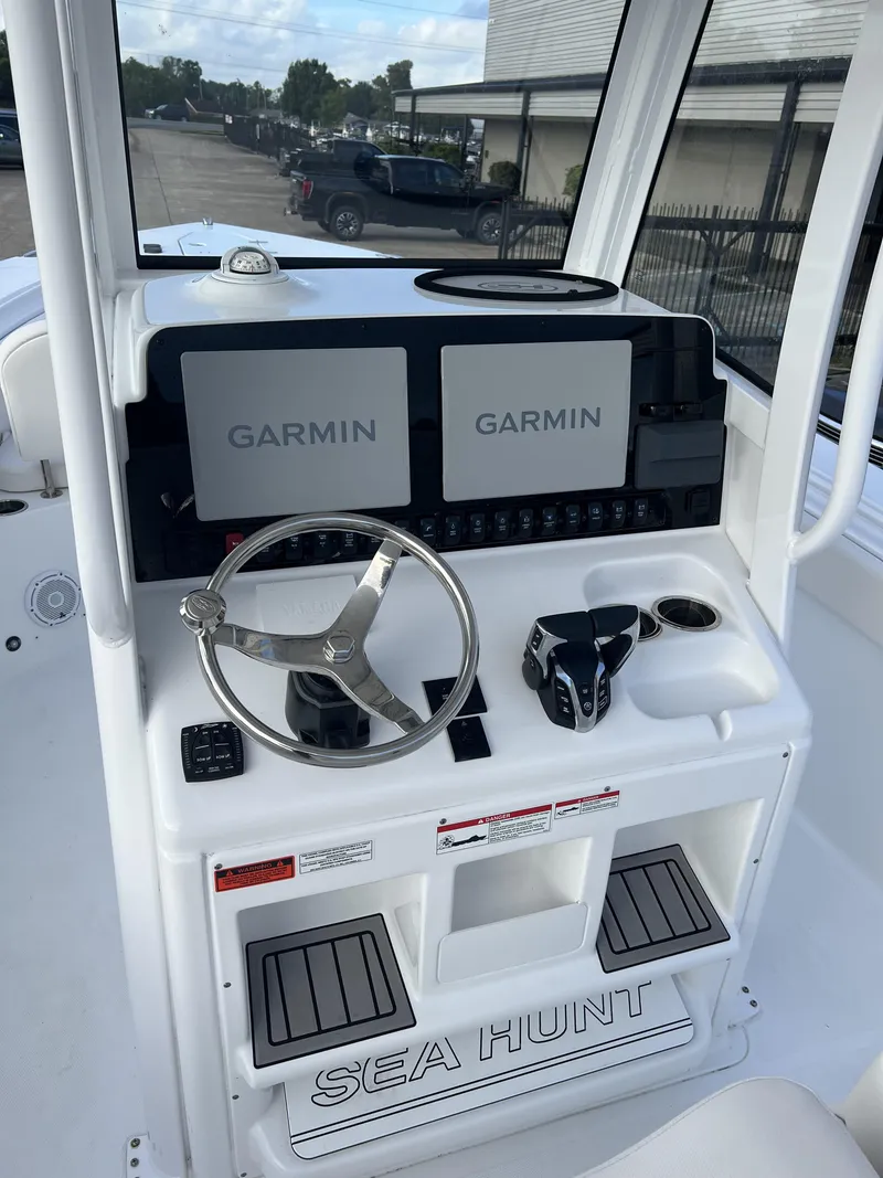 Slide: The Image of 2024 Sea Hunt Gamefish 27 FS helm with dual Garmin displays and steering wheel. - 17