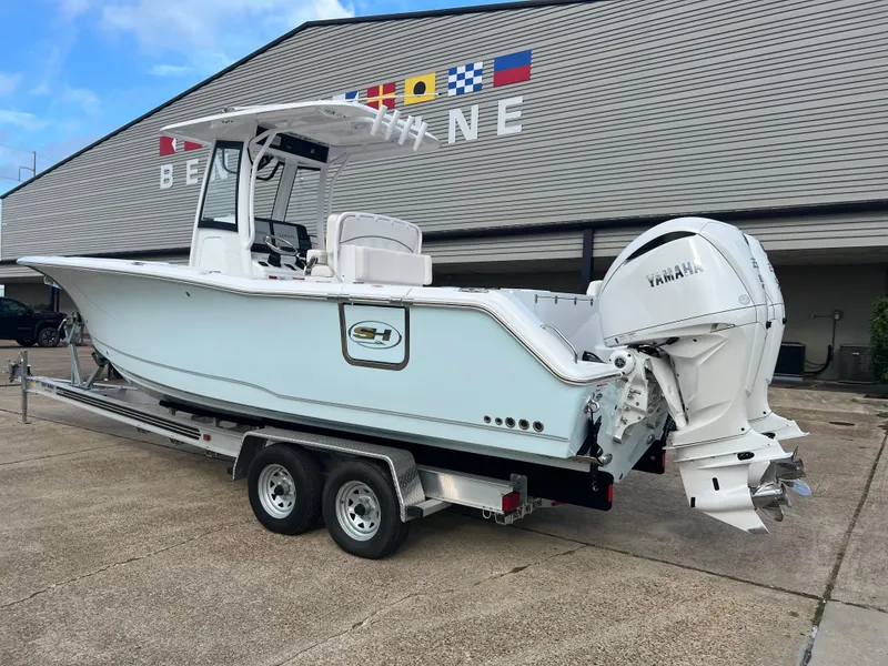 Slide: The Image of 2024 Sea Hunt Gamefish 27 FS boat on trailer, featuring Yamaha engines, parked outside. - 4