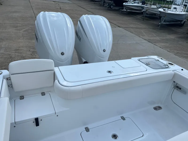 Slide: The Image of 2024 Sea Hunt Gamefish 27 FS boat with dual Yamaha engines, docked on concrete. - 8