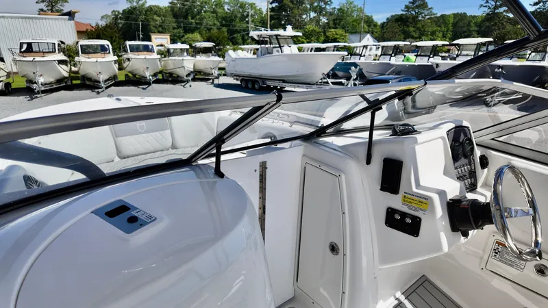 Slide: The Image of 2025 Sea Fox 228 Traveler boat interior with steering wheel and dashboard, surrounded by other boats. - 12