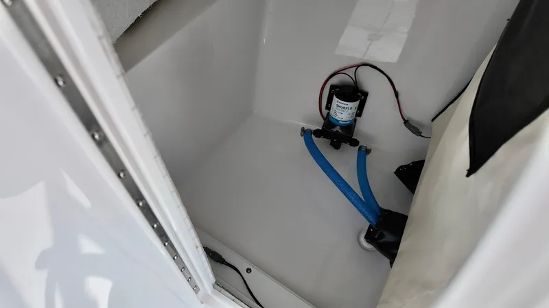 Slide: The Image of 2025 Sea Fox 228 Traveler interior compartment with pump and blue hoses. - 16