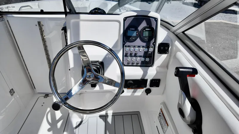 Slide: The Image of 2025 Sea Fox 228 Traveler boat dashboard with steering wheel and control panel. - 23