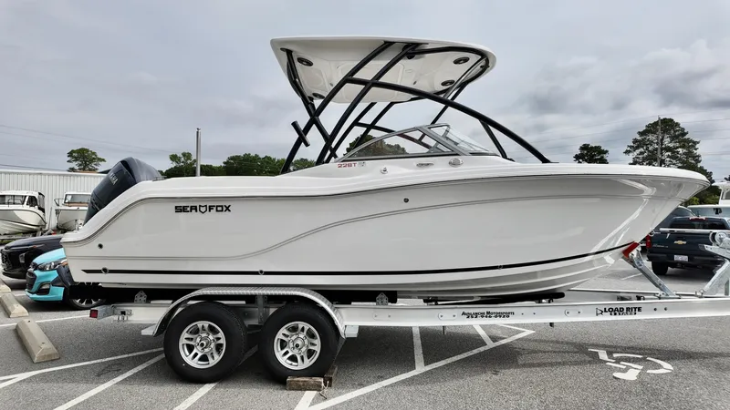 Slide: The Image of 2025 Sea Fox 228 Traveler boat on trailer, side view, in parking lot. - 4