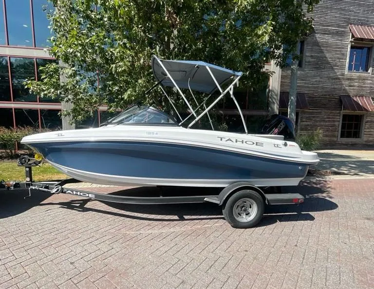 Slide: The Image of 2024 Tahoe 185 S boat on trailer, parked outdoors near building. - 1