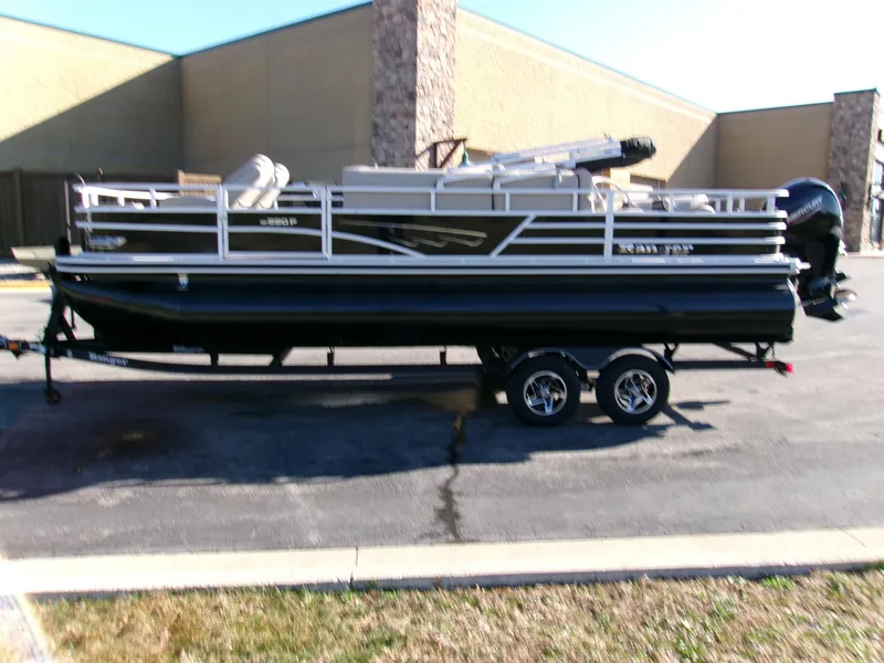 Slide: The Image of 2024 Ranger Reata 220F pontoon boat on a trailer in a parking lot. - 3