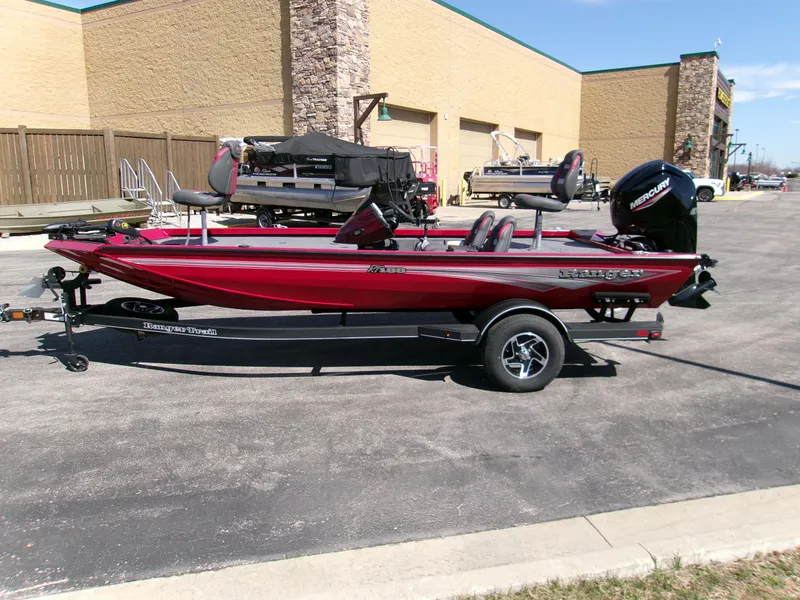 Slide: The Image of 2024 Ranger RT188 boat in red, parked on a trailer in a parking lot. - 2