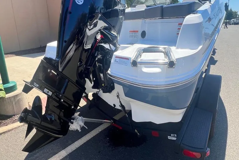 Slide: The Image of 2024 Tahoe 185 S boat with outboard motor, parked on a trailer. - 2