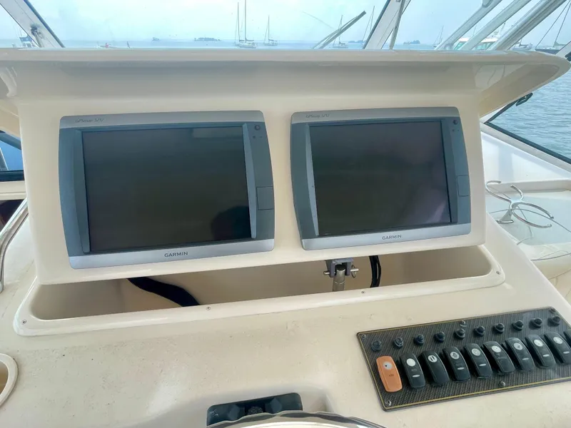 Slide: The Image of 2009 Grady-White 330 Explorer dashboard with dual Garmin displays and control panel. - 13