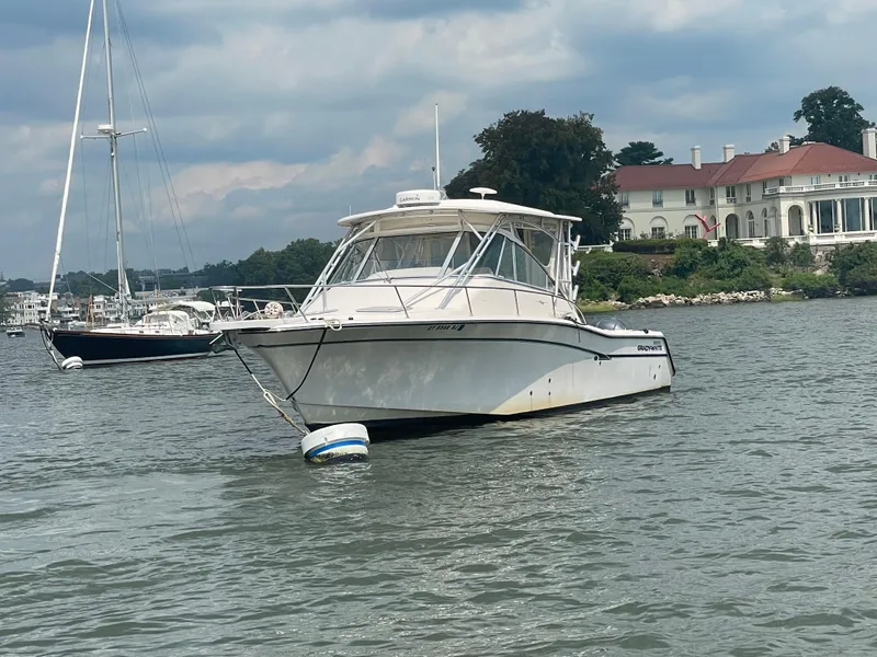 Slide: The Image of 2009 Grady-White 330 Explorer boat anchored near a waterfront mansion. - 14