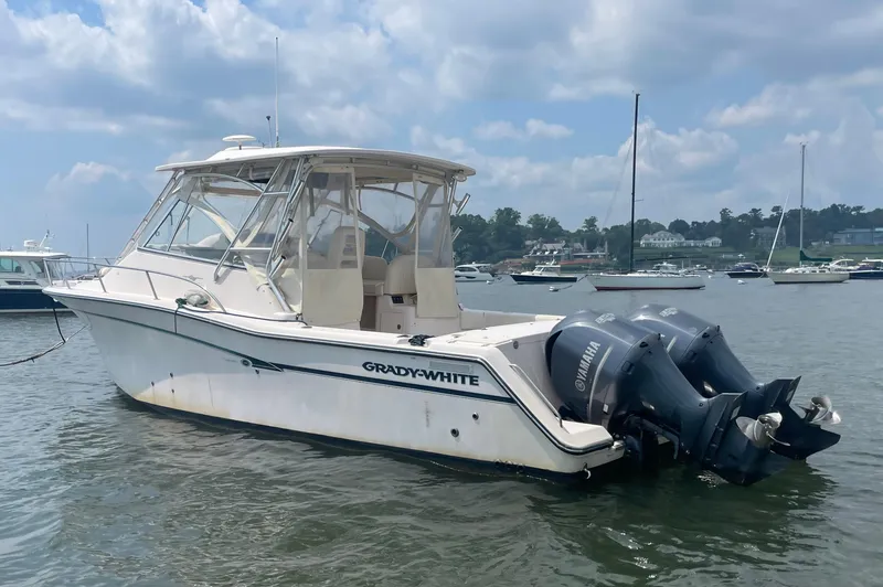 Slide: The Image of 2009 Grady-White 330 Explorer boat with twin outboard motors on a calm waterway. - 16