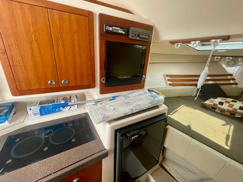 Slide: The Image of 2009 Grady-White 330 Explorer cabin interior with kitchenette and cozy seating area. - 5