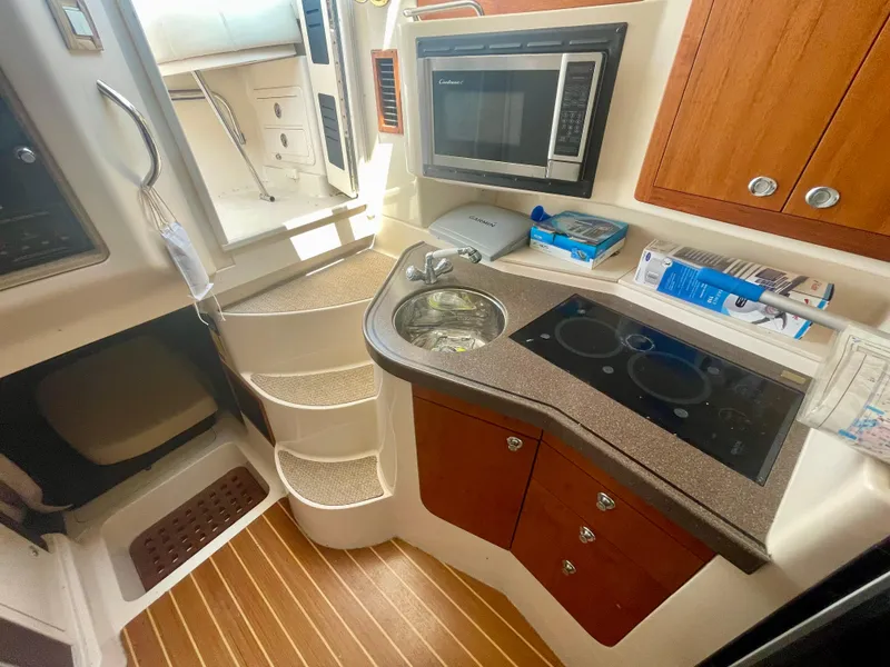 Slide: The Image of 2009 Grady-White 330 Explorer boat interior with kitchenette, microwave, and stairs. - 9