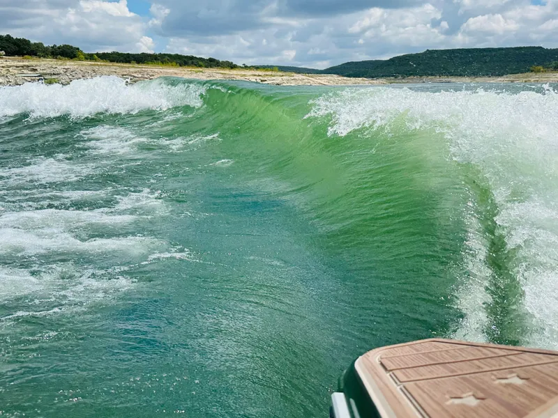 Slide: The Image of Centurion Ri245 2021 creating a large wake on a scenic lake. - 12