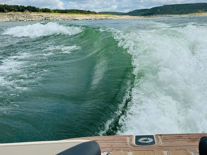 Slide: The Image of Centurion Ri245 2021 creating a large wake on a scenic lake. - 13