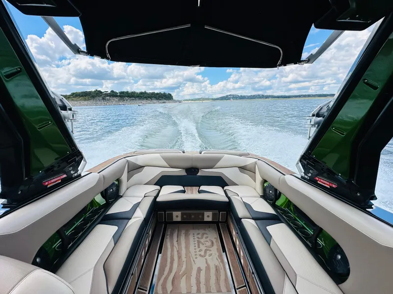 Slide: The Image of 2021 Centurion Ri245 boat interior with lake view, featuring luxurious seating and sleek design. - 15