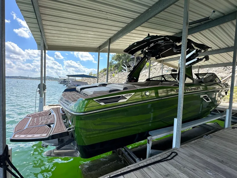 Slide: The Image of 2021 Centurion Ri245 boat in dock, vibrant green, under sunny sky. - 16