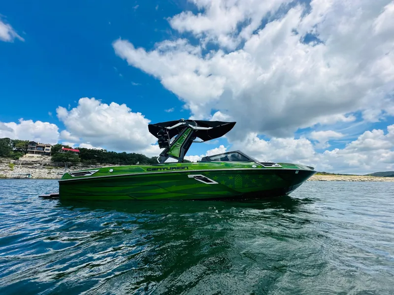 Slide: The Image of Green 2021 Centurion Ri245 boat on a lake under a blue sky. - 2
