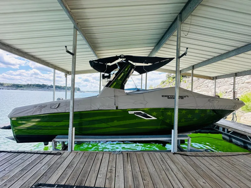 Slide: The Image of 2021 Centurion Ri245 boat in dock, covered, with green hull. - 21