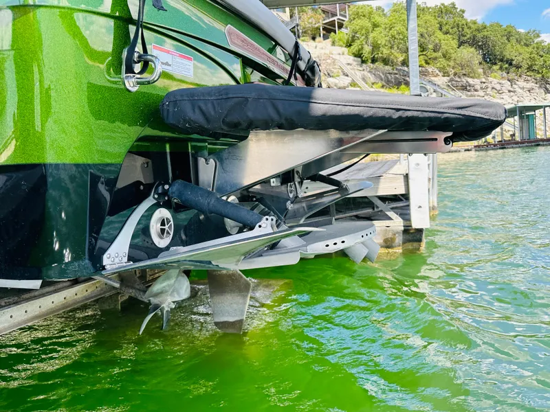 Slide: The Image of 2021 Centurion Ri245 boat with green hull, docked in clear water. - 23