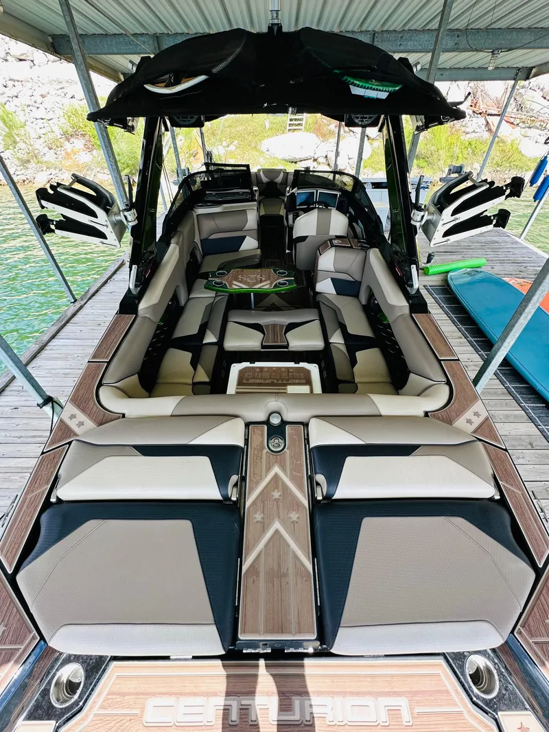 Slide: The Image of 2021 Centurion Ri245 boat with luxurious seating and sleek design in a docked setting. - 25