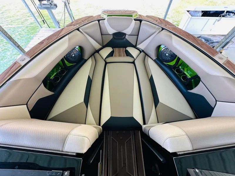 Slide: The Image of 2021 Centurion Ri245 boat interior with beige and black seating, cup holders, and speakers. - 35