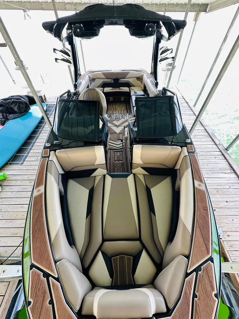 Slide: The Image of 2021 Centurion Ri245 boat with luxurious seating and sleek design in a docked setting. - 39