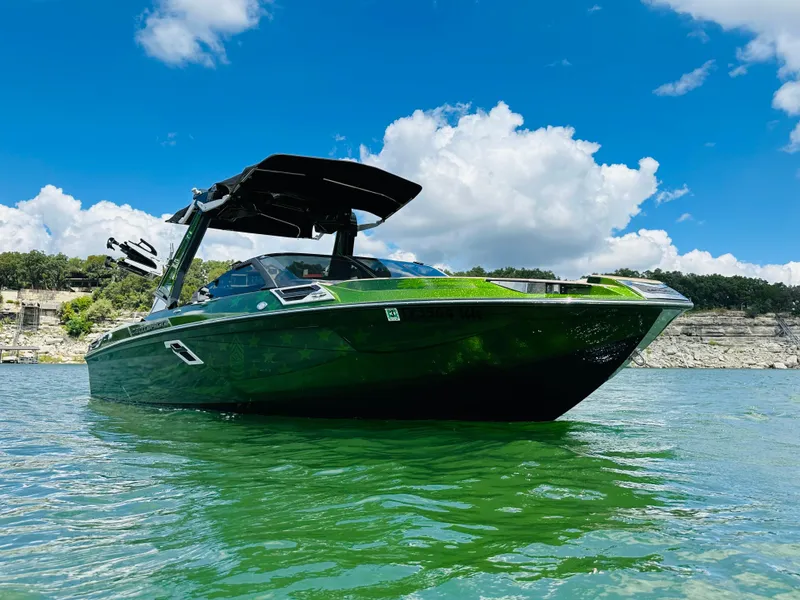 Slide: The Image of 2021 Centurion Ri245 boat on clear water under blue sky. - 4