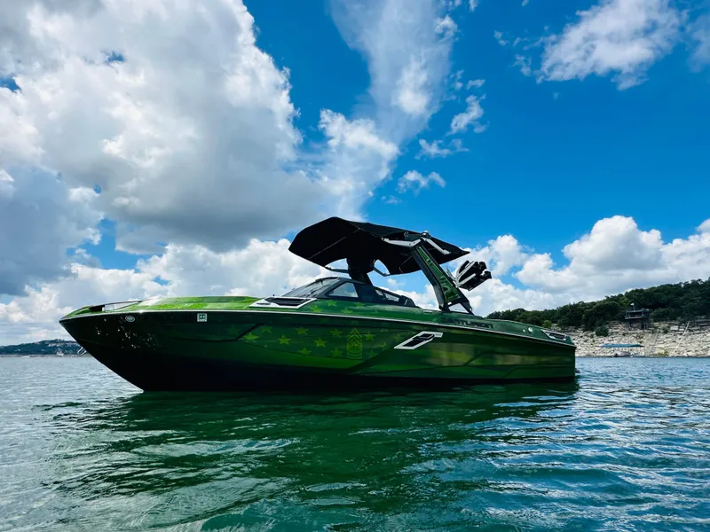 Slide: The Image of 2021 Centurion Ri245 boat on water under blue sky with clouds. - 6