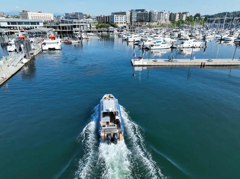 Slide: The Image of Life Proof 35 Full Cabin boat navigating marina, 2023 model, surrounded by yachts and waterfront buildings. - 6