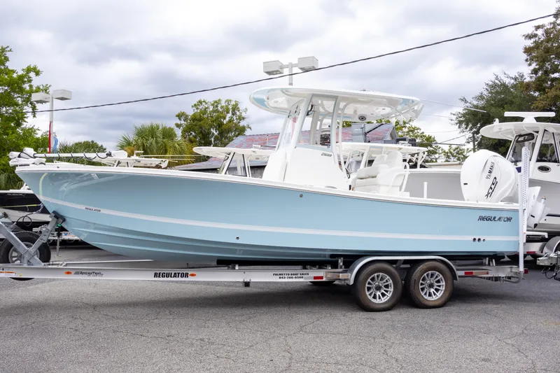 The Image of 2025 Regulator 26XO boat on trailer, light blue hull, parked outdoors. - 0